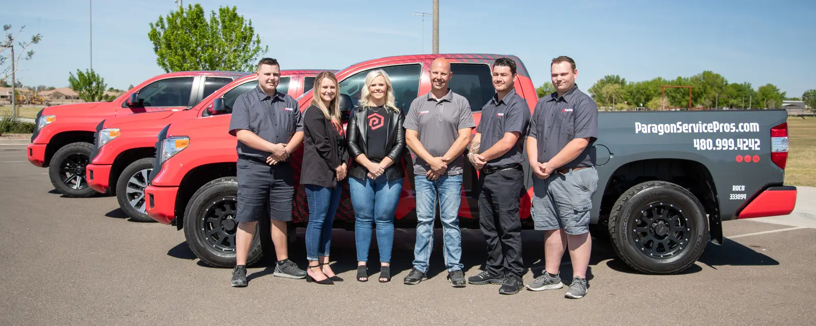 The Paragon Service Pros team with their red service trucks