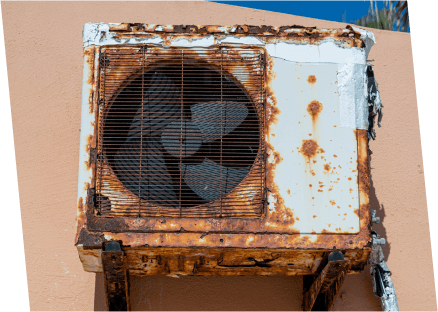 A rusted air conditioner mounted on a wall, showcasing wear and age, associated with Paragon Service Pros.