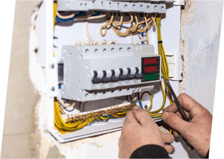 A technician from Paragon Service Pros is focused on a panel, skillfully managing various wires and connections.