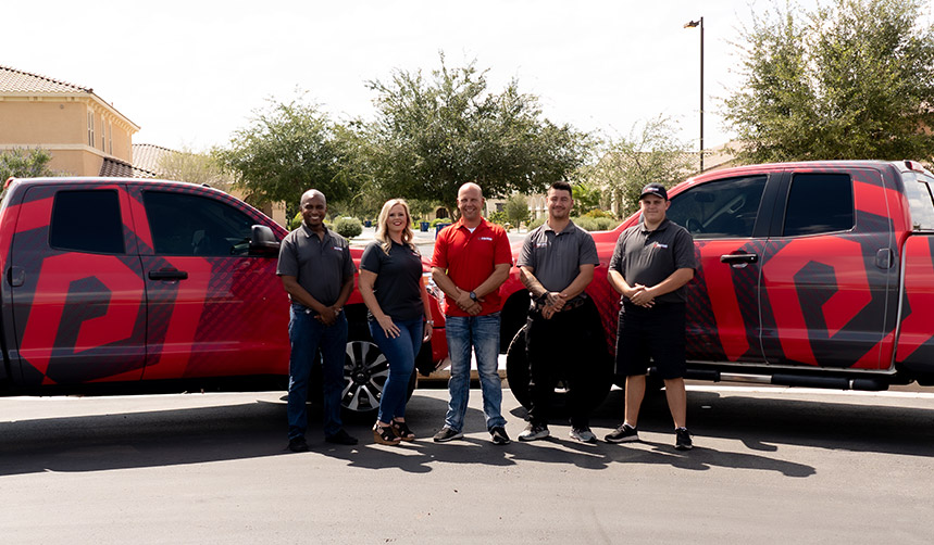 A group of Paragon Service Pros standing proudly beside their trucks, showcasing teamwork and professionalism in their field.