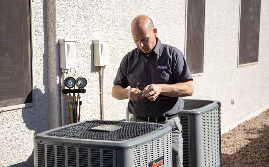 A technician from Paragon Service Pros is diligently working on an HVAC unit, ensuring optimal performance and efficiency.
