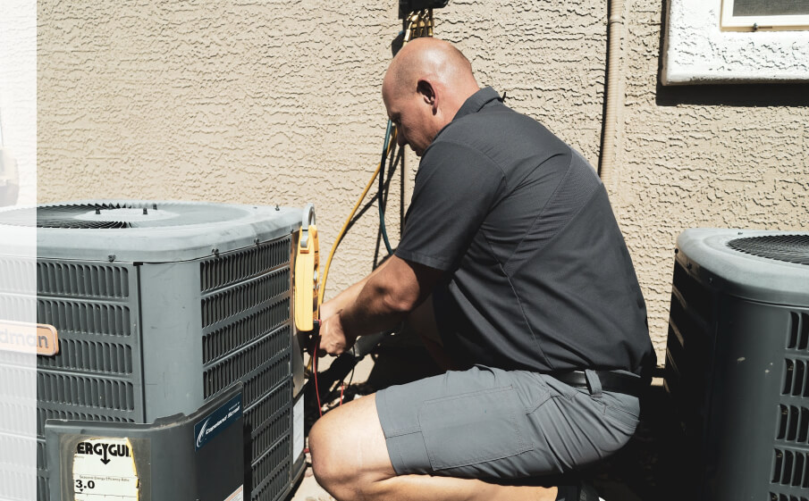 Expert technician kneeling beside an outdoor air conditioning unit, making adjustments to enhance cooling efficiency and maintain reliable operation.