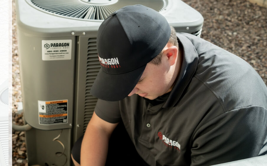 AC technician wearing a branded uniform, inspecting and performing maintenance on an outdoor air conditioning unit to ensure efficient operation and cooling.