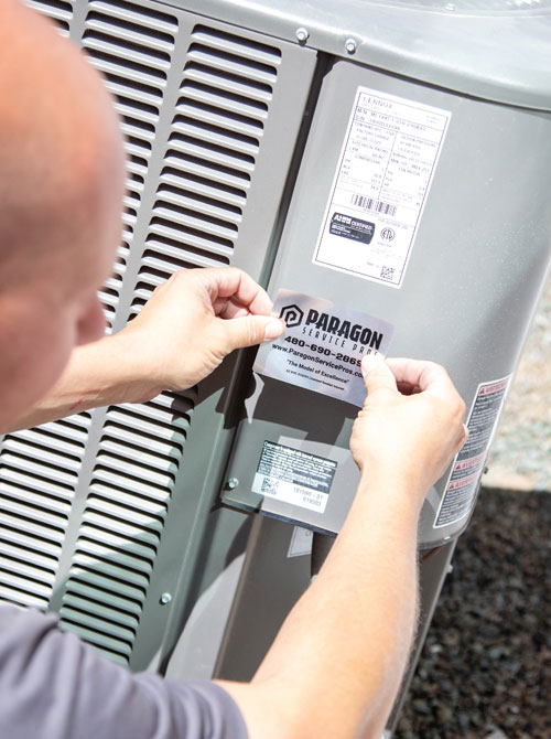 A technician from Paragon Service Pros repairs an air conditioner, ensuring optimal performance and comfort.
